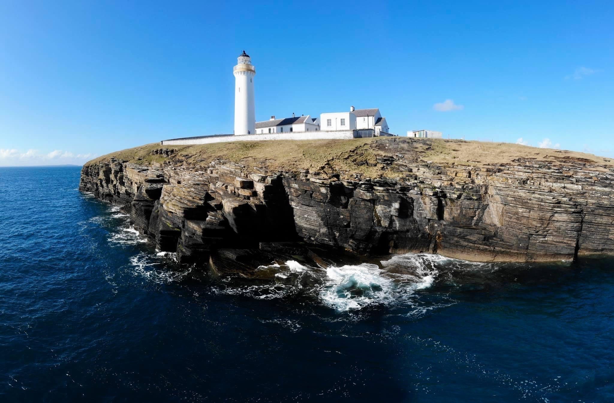 The view of Cantick Head Lighthouse from the sea in Orkney in Scotland