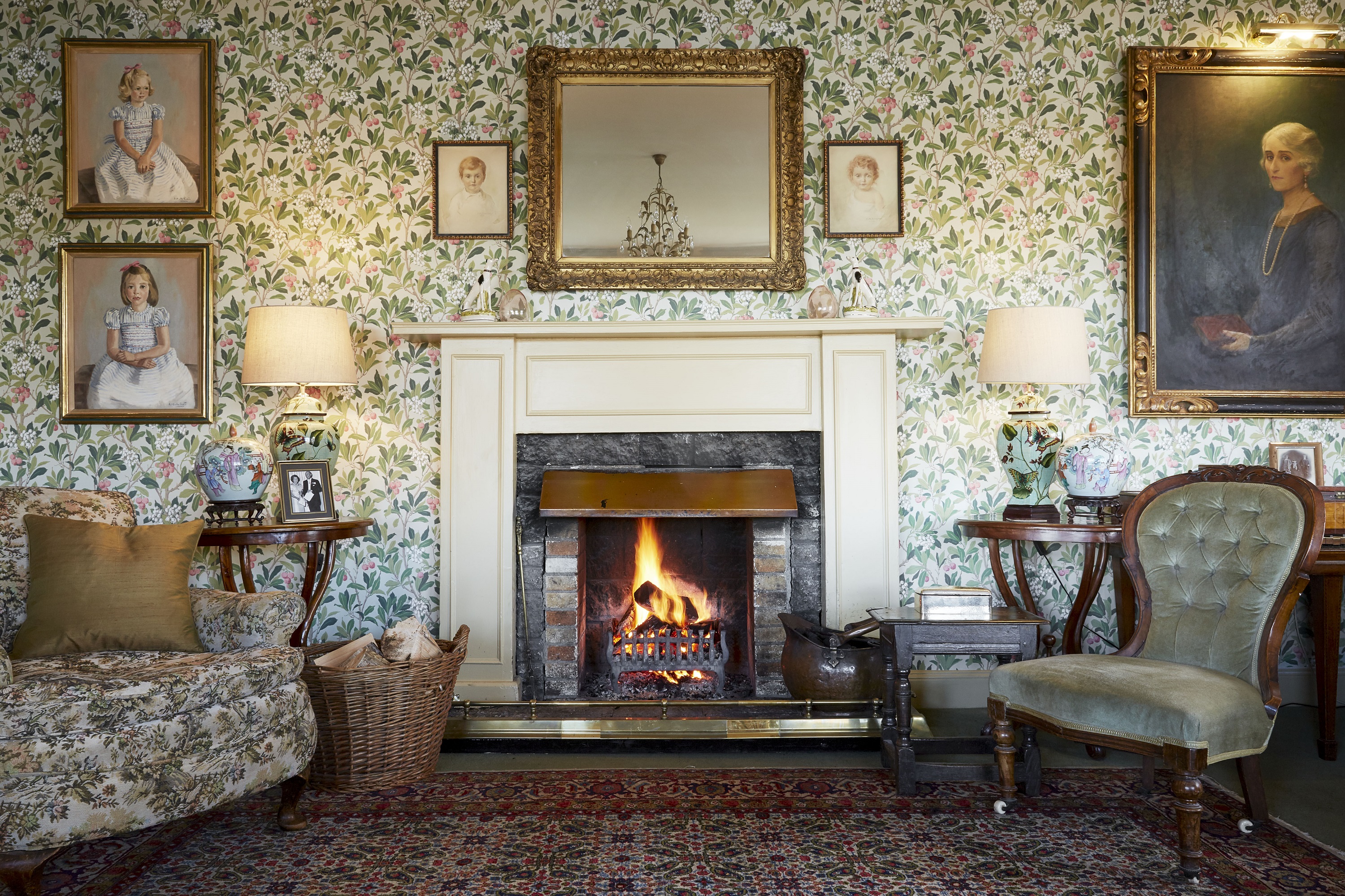 The ornate fireplace and wallpaper in the drawing room of the Kinloch Lodge in the Scottish Highlands